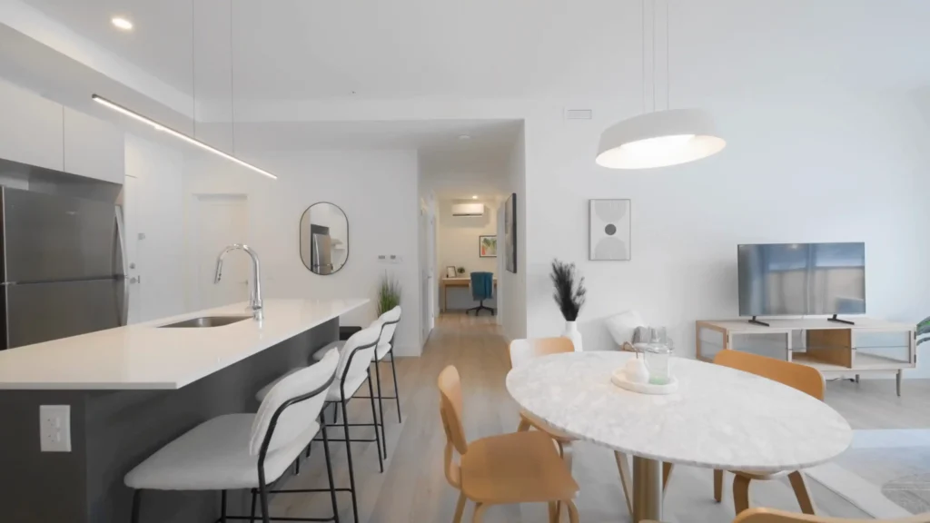 Cuisine et salle à manger moderne avec table ronde, tablier blanc et évier intégré